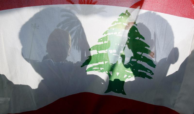 People wave a Lebanese national flag during a protest in Central Beirut December 11, 2006.