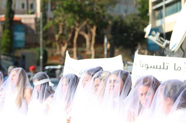 Demonstration outside Lebanon's Parliament on December 6, 2016, with women in white dresses and wrapped in bandages, calling for the repeal of article 522 of the penal code.
