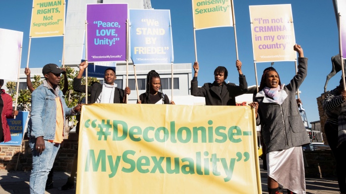 People hold banners in support of LGBTQ rights outside the high court which made a landmark ruling in favor of LGBTQ communities in Windhoek, Namibia, June 21, 2024.