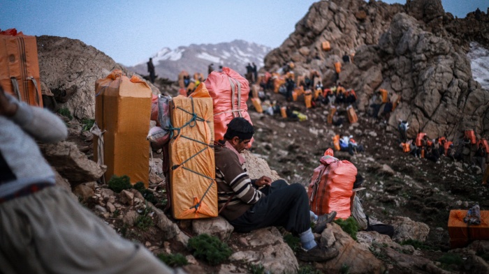 Kulbars carry goods on their backs along the mountains of the Iran-Iraq border, Kurdistan, Iran, April 29, 2017.