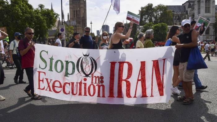 Protesters hold a banner reading 'Stop execution in Iran' during a march in Parliament Square, London, September 16, 2023. 