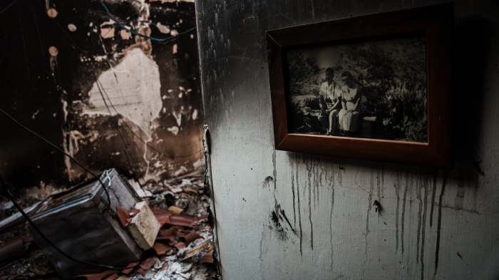 صورة عائلية معلقة على جدار داخل منزل محترق في كيبوتس بئيري في أعقاب هجوم 7 أكتوبر/تشرين الأول 2023 الذي شنته الفصائل الفلسطينية المسلحة على جنوب إسرائيل، 14 أكتوبر/تشرين الأول 2023.