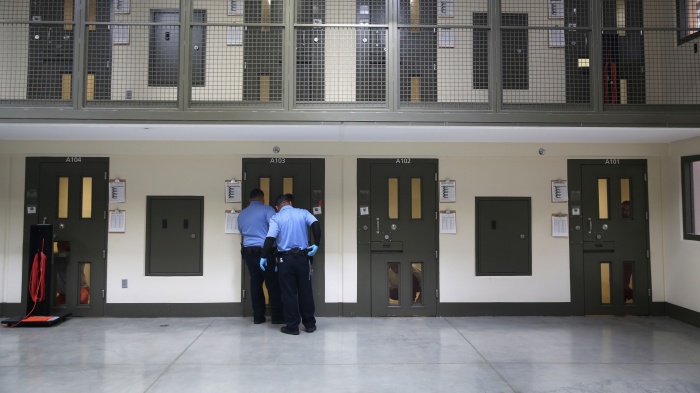 Guards prepare to escort an immigrant detainee from his 'segregation cell' back into the general population at the Adelanto Detention Facility, Adelanto, California, on November 15, 2013. 