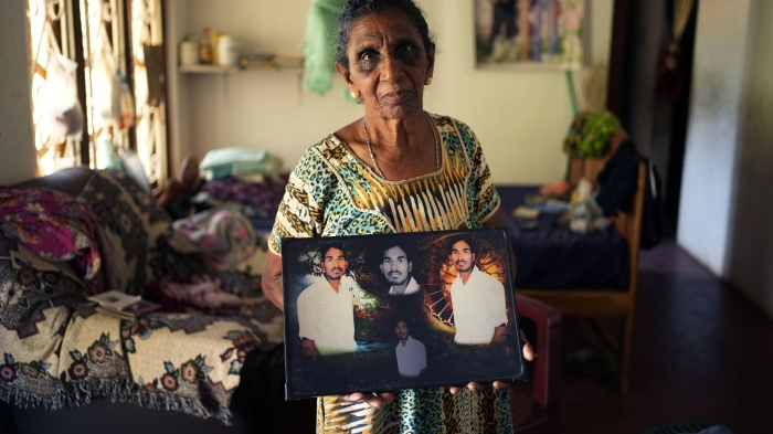 Soosai Victoria shows photographs of her missing son at her home in Mullaitivu, Sri Lanka, May 7, 2024. 