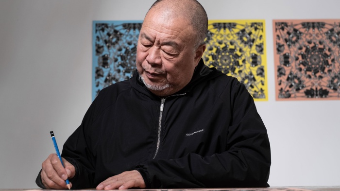 Artist Ai Wei Wei signs a lithograph print