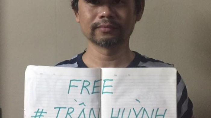 Phan Van Bach carries a sign supporting political prisoner Tran Huynh Duy Thuc.