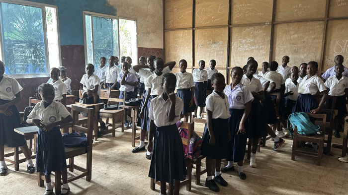 Students standing at their desks in a classroom