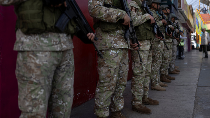Military officers patrol a street after the government declared a state of emergency in Lima on October 22, 2025.