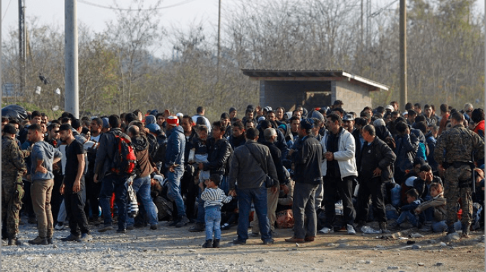 Migrants stand in line to enter a registration camp after crossing the border from Greece in Gevgelija.