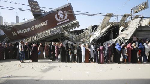 People line up for bread at a partially collapsed but still operational bakehouse in Nuseirat refugee camp in Deir al Balah, Gaza, November 4, 2023.