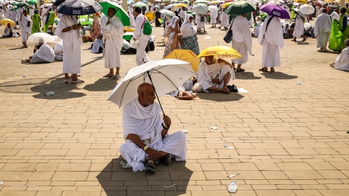 Pilgrims use umbrellas to shade themselves from the sun as they arrive at the base of Mount Arafat, also known as Jabal al-Rahma or Mount of Mercy, during the annual hajj pilgrimage on June 15, 2024. 