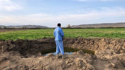 A member of the Azerbaijan National Agency for Mine Action looks at the crater of a Scud-B ballistic missile that hit on October 5, in a field near Babi village, Fizuli district.