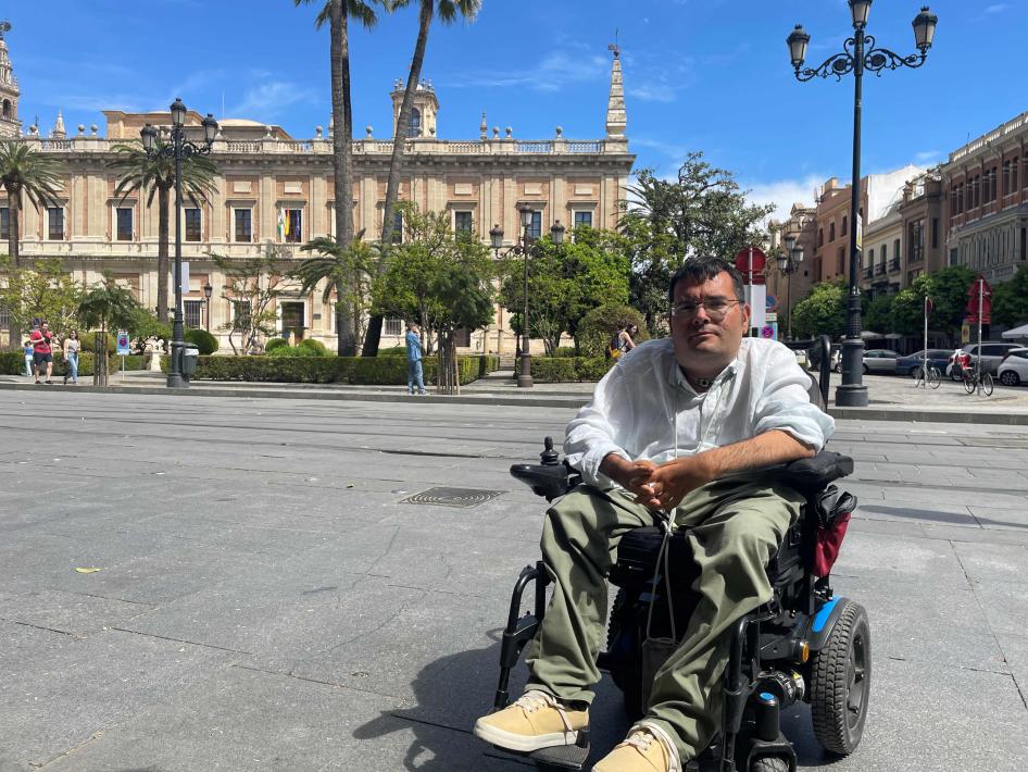 Carlos Reina Rosales, 35, sitzt in seinem elektrischen Rollstuhl vor einem Museum im Zentrum der andalusischen Stadt Sevilla (Andalusien, Spanien).