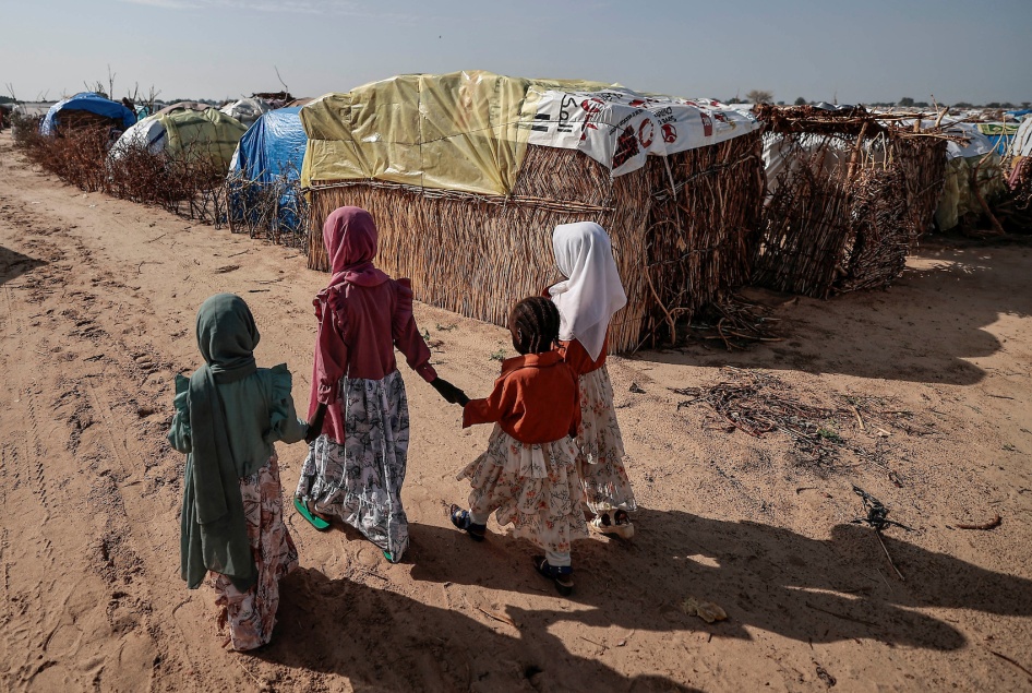 Sudanese girls who fled the conflict in Sudan's Darfur region, walk beside makeshift shelters in Adre, Chad, July 29, 2023.