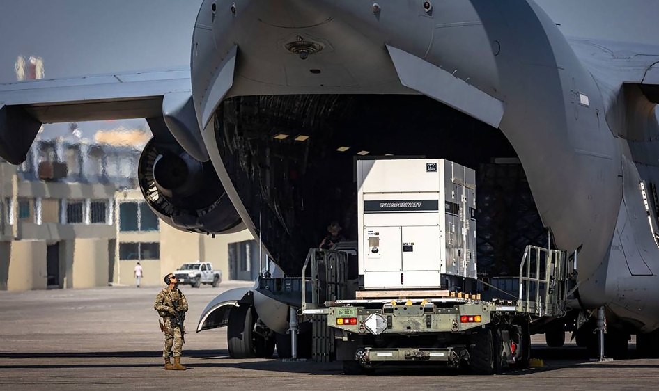 Un soldat supervisait le déchargement d’une caisse de l’arrière d'un avion-cargo C-17 de l’Armée de l’air américaine sur le tarmac de l'Aéroport international Toussaint Louverture de Port-au-Prince, en Haïti, le 15 mai 2024.