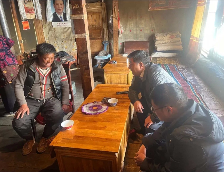 Le Secrétaire adjoint du Parti communiste chinois du comté de Gonjo, dans la Région autonome du Tibet, et un collègue (à droite), discutaient avec un habitant du village de Sa-ngen au sujet du projet de relocalisation des villageois vers un site choisi par le PCC, en mars 2024. 
