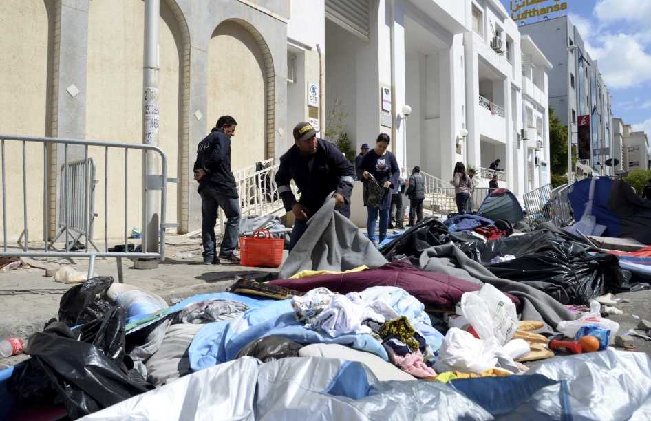 عمال بلديون ينظفون مخيما مؤقتا أمام "المنظمة الدولية للهجرة" بعد محاولة قوات الشرطة إخلاء المخيم، في تونس العاصمة، تونس، 11 أفريل/نيسان 2023. 