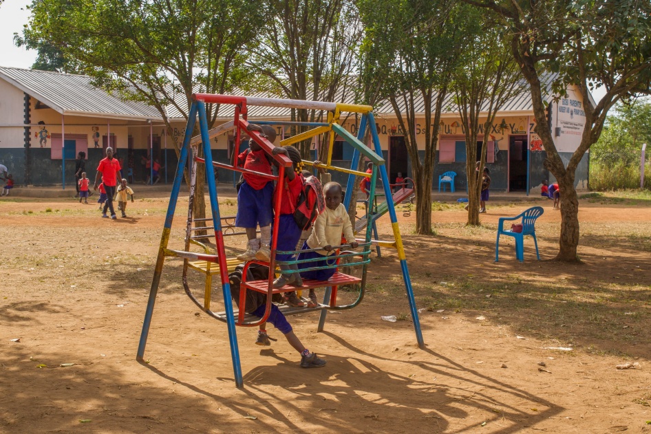 Children play on a swingset in a school playground