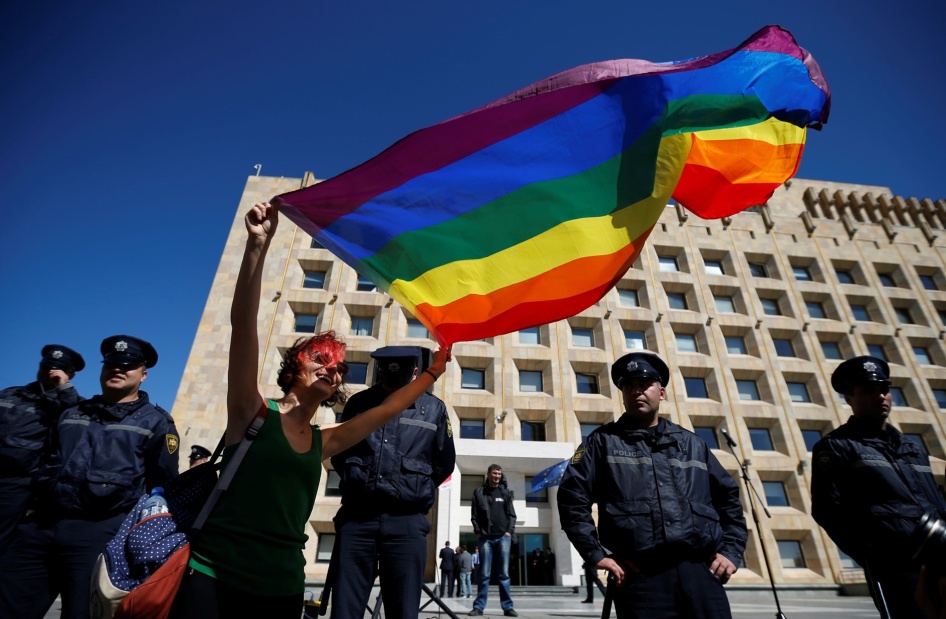 Une manifestante brandissant un drapeau LGBT