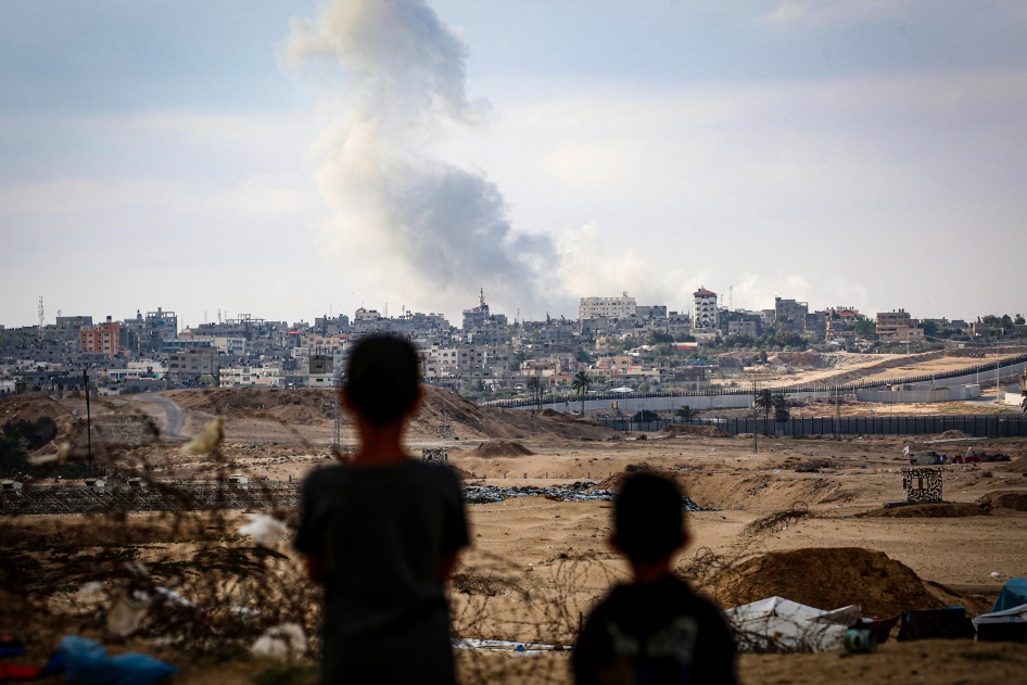 أطفال يشاهدون غارات جوية إلى الشرق من رفح في جنوب قطاع غزة، 13 مايو/أيار 2024.
