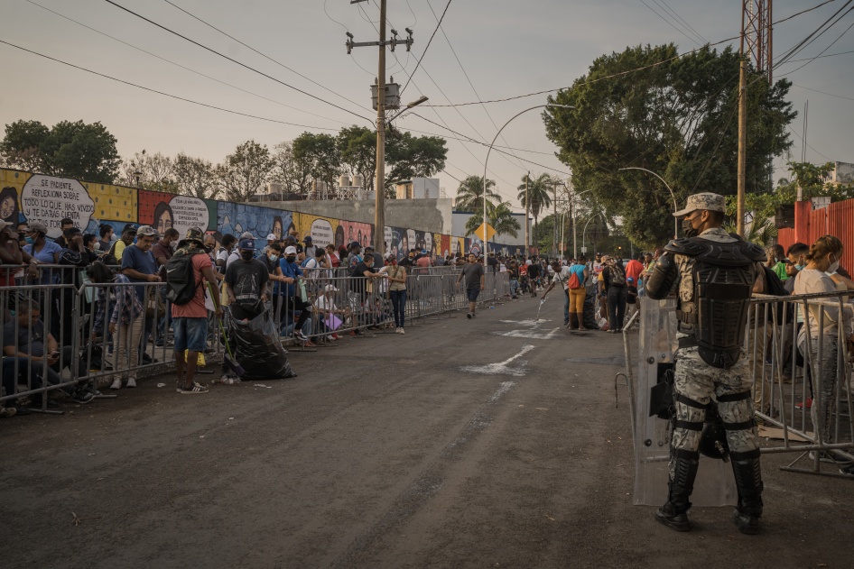 A member of the national guard keeps order as migrants wait outside the Mexican Commission for Refugee Assistance to get their applications processed in Tapachula, Chiapas state, Mexico, April. 12, 2022. 