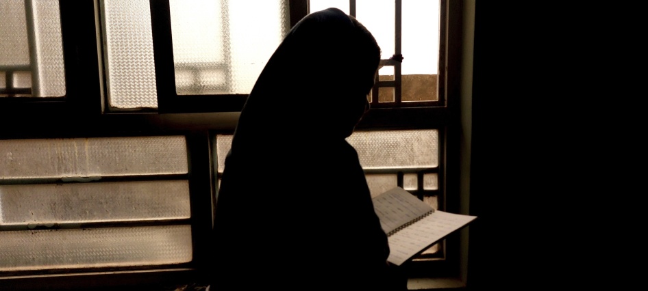 A 15-year-old girl reads out of a notebook because she is barred from attending school in Kabul, Afghanistan, March 2024.