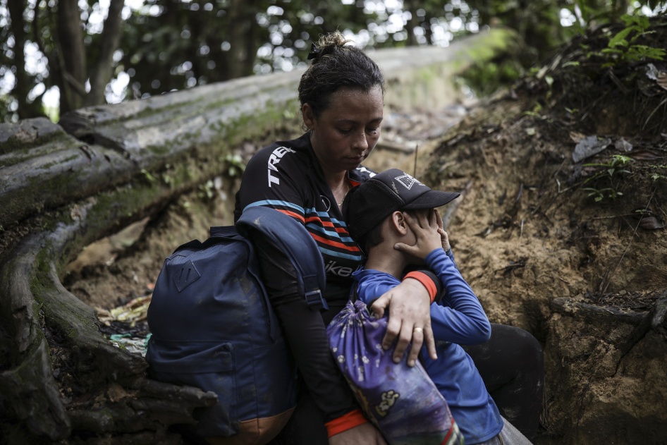 A woman embraces her son in a jungle