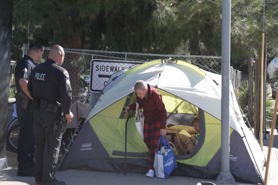 La policía saca a una mujer sin techo de su tienda de campaña durante una operación de limpieza en Los Ángeles, octubre de 2023. 