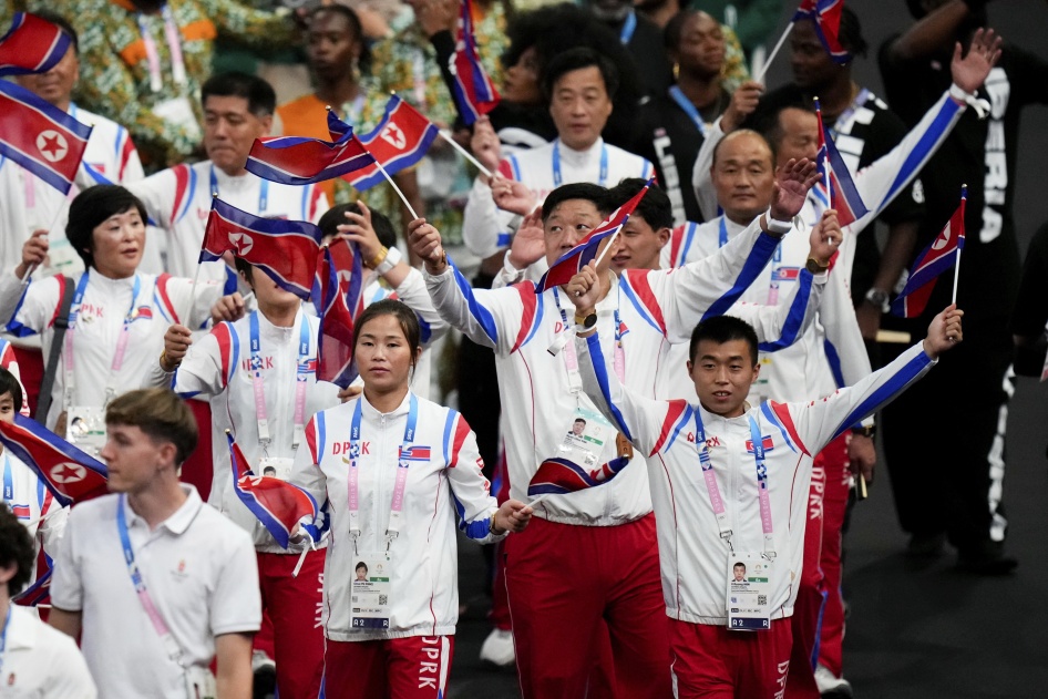 Athletes in uniform wave flags 