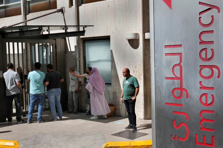 People stand outside a hospital emergency room