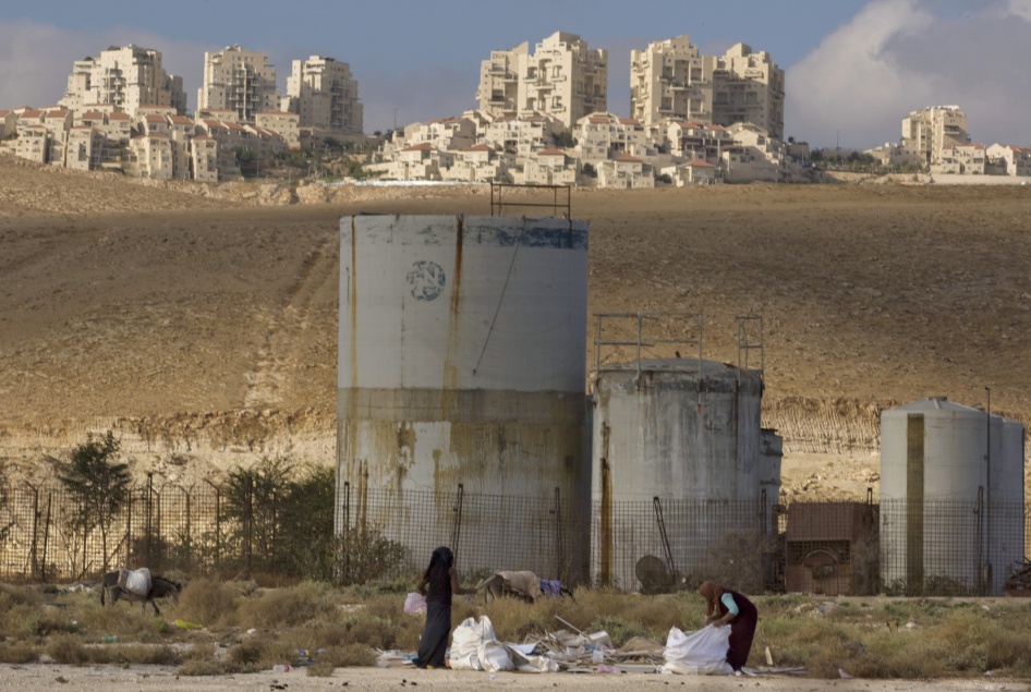 People collect scrap timber in the Mishor Adumim industrial zone near the Israeli settlement of Maaleh Adumim, November 22, 2010.