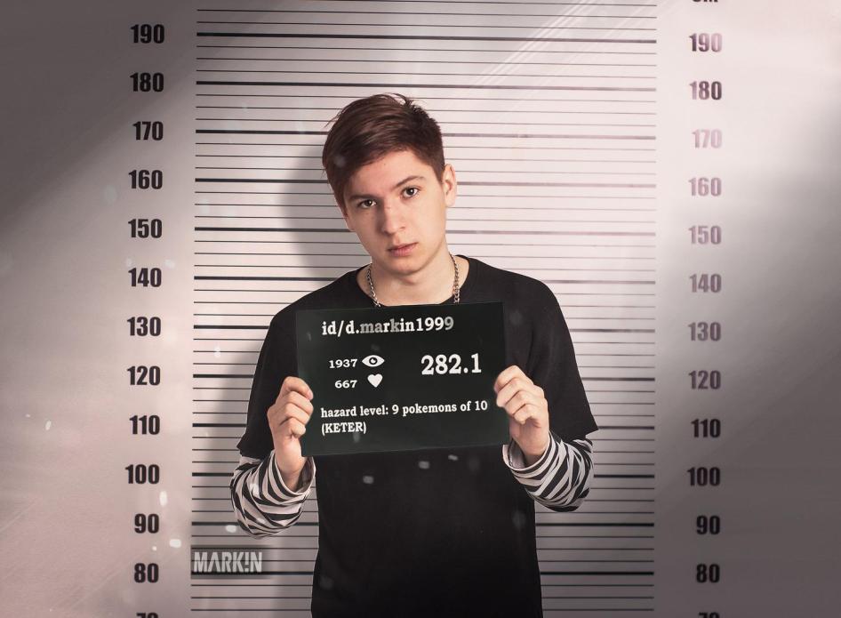 A satirical mugshot depicting Daniil Markin. The nameplate indicates his page on the social media platform VKontake and Russia's Criminal Code Article 282.1 ("incitement of hatred against a religious group"). He faces up to five years in prison under this