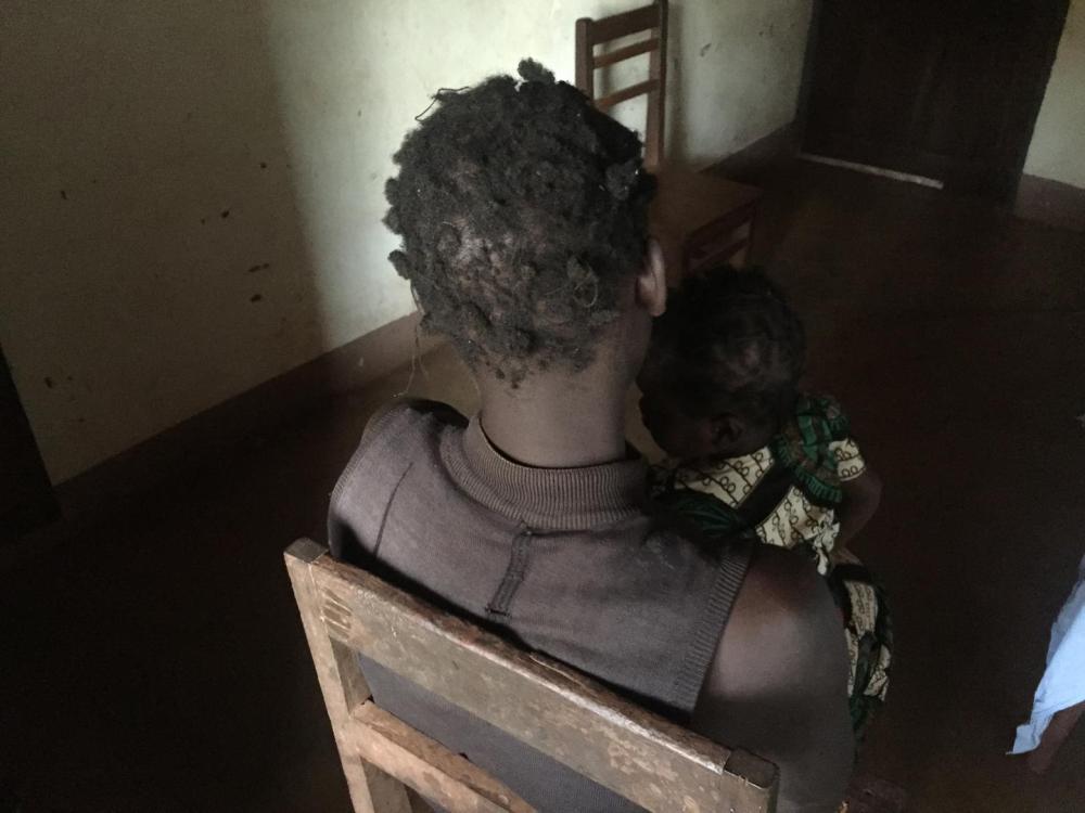 « Margaret », âgée de 28 ans, tient sur ses genoux sa fille de deux ans dont le père est un militaire ougandais.