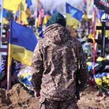 Individual with back to camera faces group of Ukrainian flags. 