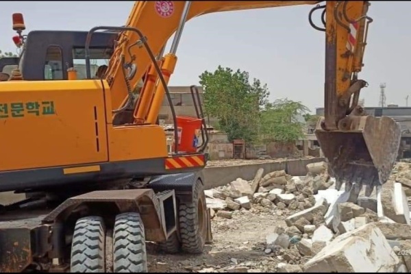 A bulldozer demolishing a house