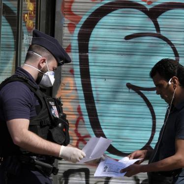 French Police officer wearing a protective surgical face masks against coronavirus, checks documents of a man in Paris, as a strict lockdown comes into in effect in France to stop the spread of COVID-19. Paris, France, 16 April 2020.