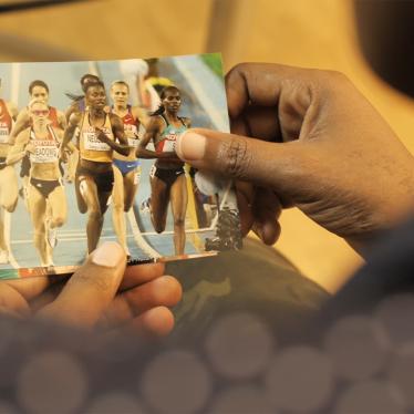 Una mujer sostiene una foto de un grupo de corredoras compitiendo
