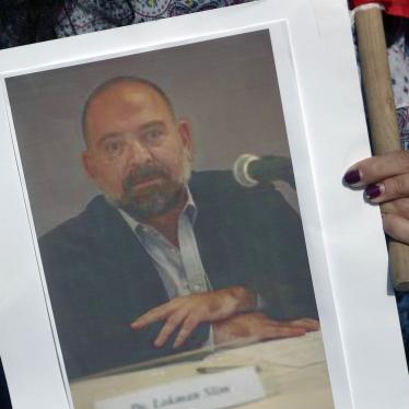 A protestor holds a picture of Lokman Slim, a writer and Hezbollah critic who was found murdered on February 4, 2021.