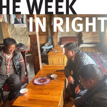 Three individuals gather around a table in Tibet. 