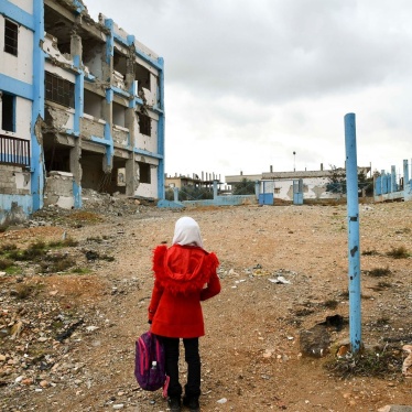 A 14-year-old girl looks at her old school, which was damaged by conflict, in Dara’a Albalad, Syria, on February 7, 2022. © UNICEF/UN0635253/Shahan