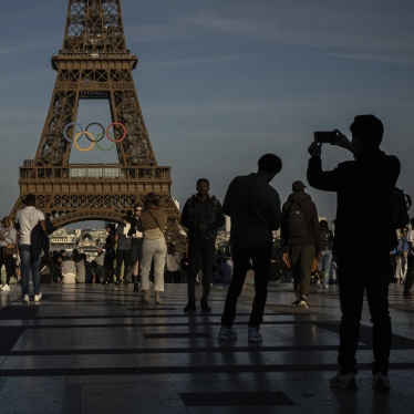 People take photos of the olympic rings at the Eiffel Tower