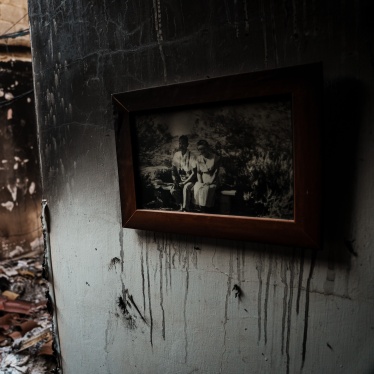 A framed family photo hung up on the wall of a burned home