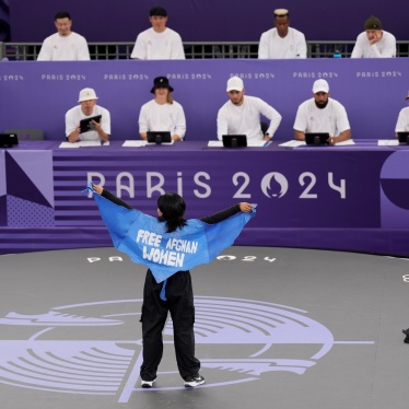 A woman wears a cape that reads "Free Afghan Women" at the Paris Olympics