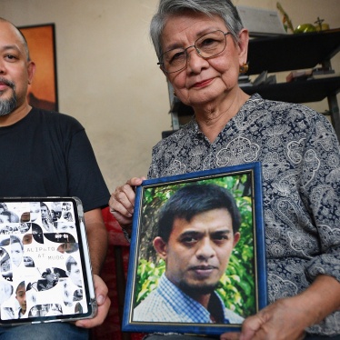 Edita Burgos (R) holds a portrait of her missing son, Jonas Burgos, while posing with her younger son JL Burgos, who directed the film “Alipato at Muog," a documentary about Jonas’ forced disappearance, Cinemalaya Film Festival, Pasay, Philippines, August 1, 2024. 