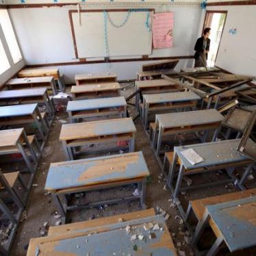 A man looks at a damaged classroom in a school after an air strike in Sanaa April 28, 2015. 