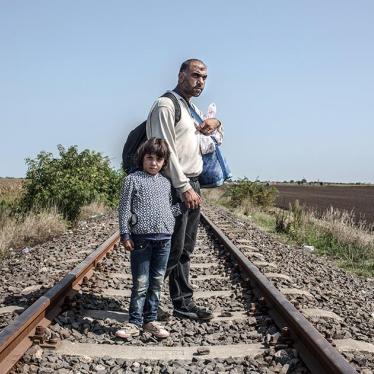 Syrian refugees, Hassan, 35, and his daughter Tasneem, 5, stand on train tracks in Hungary after crossing the border with Serbia on September 3, 2015. 