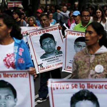 Relatives carry photos of some of the 43 missing students of the Ayotzinapa teachers' training college during a protest to mark the eleven-month anniversary of their disappearance in Mexico City, Mexico on August 26, 2015.