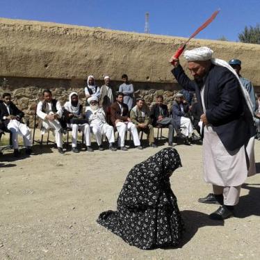 An Afghan judge hits a woman with a whip in front of a crowd in Ghor province, Afghanistan August 31, 2015.