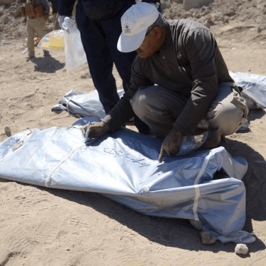 A member from the Iraqi forensic team writes on the body bag of remains belonging to Shi'ite soldiers from Camp Speicher who have been killed by Islamic State militants at a mass grave in the presidential compound of the former Iraqi president Saddam Huss