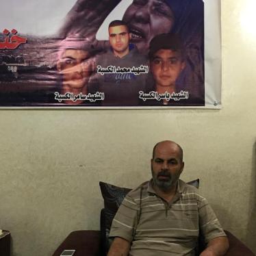 Sami al-Kasbeh sits under a poster of his three dead children, Qalandia Refugee Camp, Palestine, April 24, 2016.